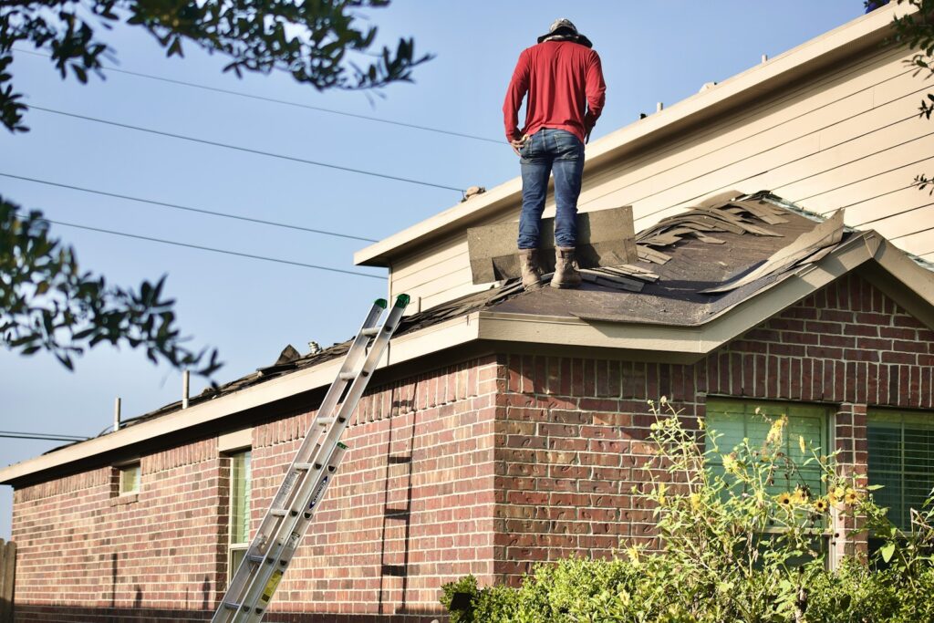 a man standing on the roof of a house for Roofing Website Design page