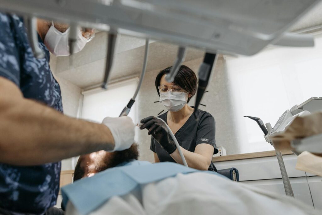 Two dentists performing a dental procedure on a patient in a modern clinic environment for use in small business website price page