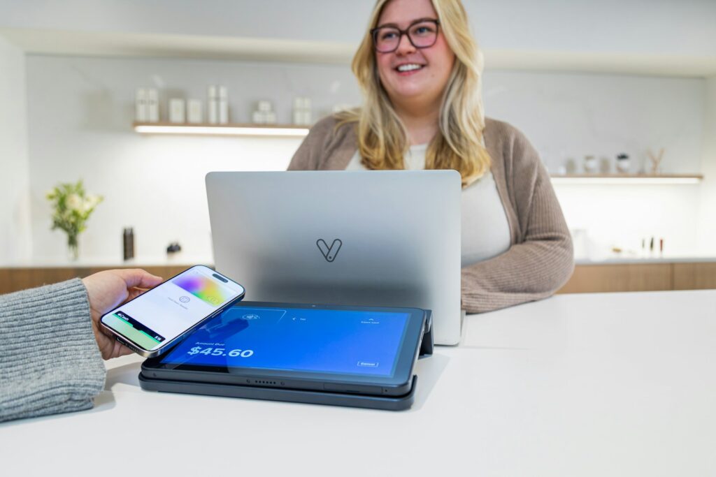 easy small business website builder header image of woman in store behind her laptop/pos system